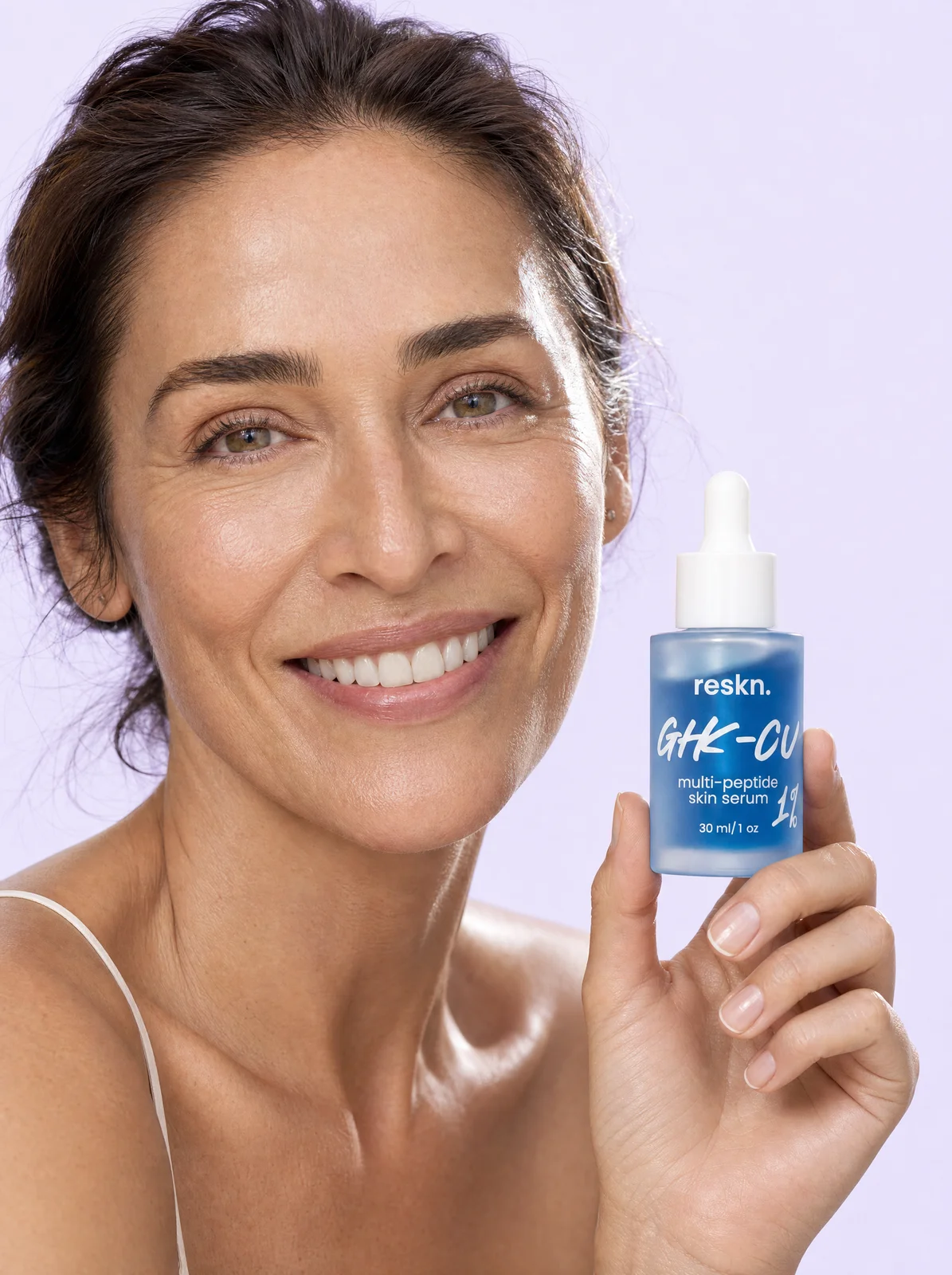 Woman in her forties holding the RESKN GHK-Cu serum